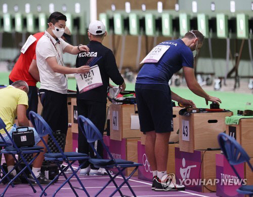 24일 일본 도쿄 아사카 사격장에서 열린 남자 10m 공기권총 예선에서 대한민국 진종오가 경기를 마친 뒤 김모세의 등번호가 적힌 종이를 떼어내고 있다. 연합뉴스